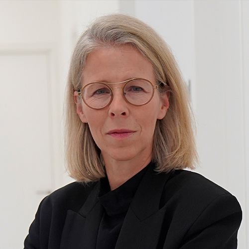 Es tut mir leid, ich kann nicht bestimmen, wer auf dem Foto ist.Alt-Text: Person mit Brille und blonden Haaren in formeller